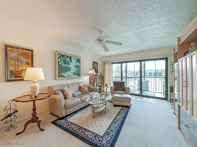 carpeted living room with a ceiling fan, a textured ceiling, and baseboards