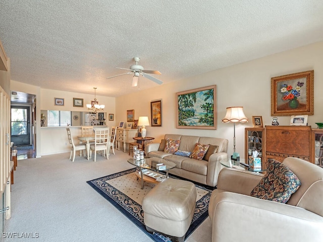 carpeted living area with a textured ceiling and ceiling fan with notable chandelier