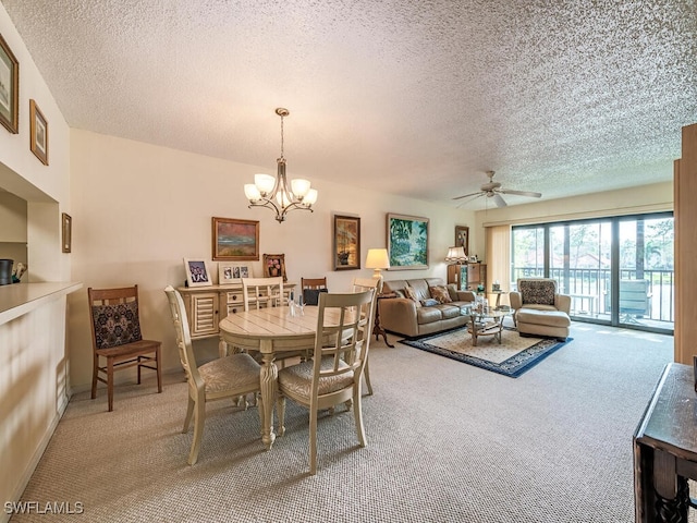 dining area with a textured ceiling, ceiling fan with notable chandelier, carpet flooring, and baseboards