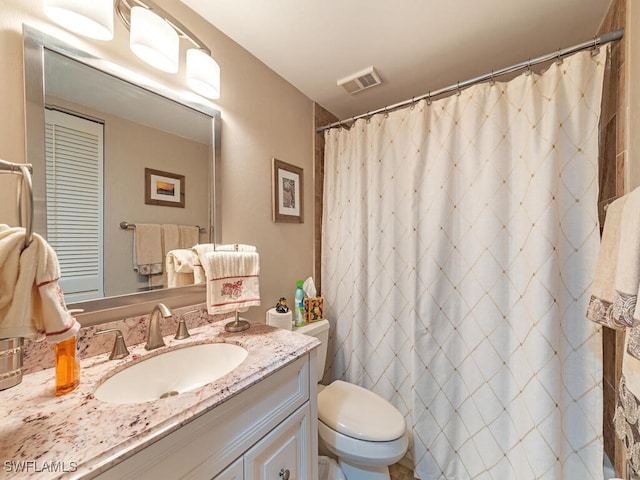 bathroom with a closet, visible vents, a shower with shower curtain, toilet, and vanity