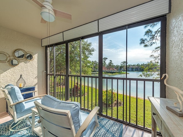 sunroom with ceiling fan and a water view