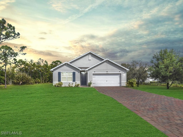 ranch-style home featuring a front yard, decorative driveway, and an attached garage