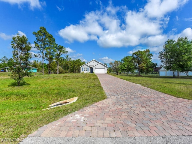 view of front of house featuring a front lawn, decorative driveway, and a garage