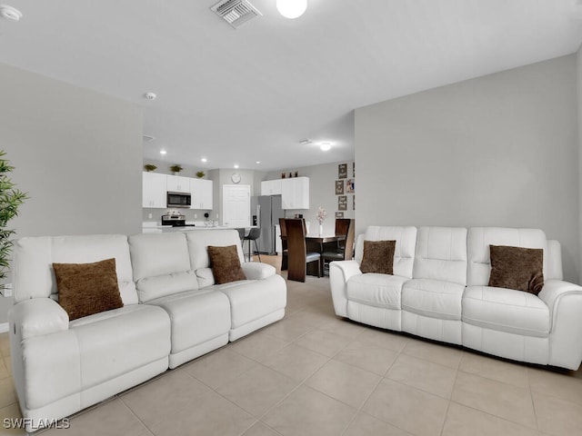 living area with light tile patterned flooring, recessed lighting, and visible vents