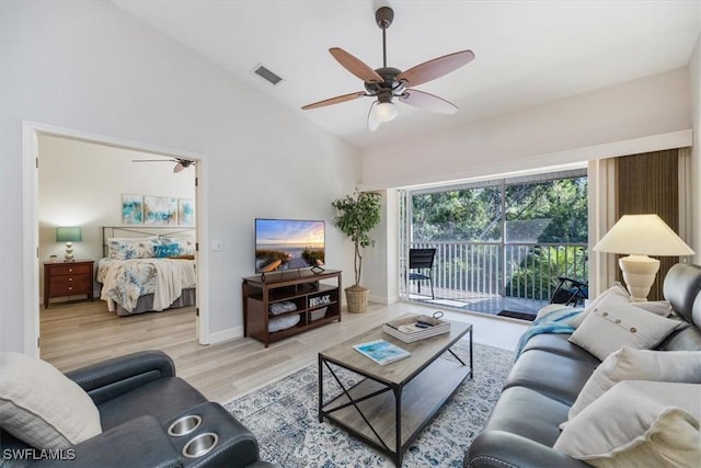 living area featuring ceiling fan, visible vents, vaulted ceiling, and wood finished floors