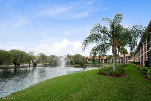 view of property's community featuring a lawn and a water view