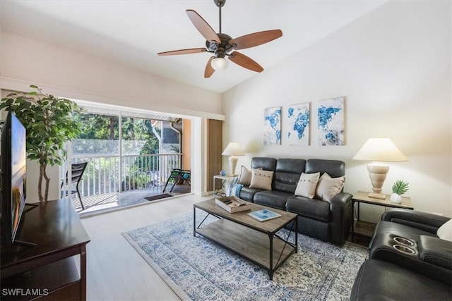 living area featuring lofted ceiling, a ceiling fan, and wood finished floors