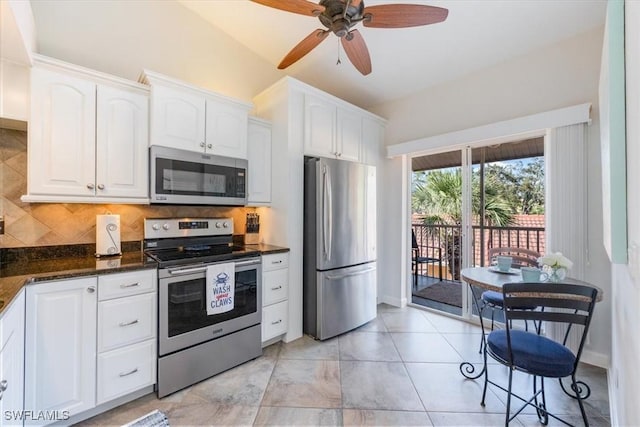 kitchen with stainless steel appliances, white cabinetry, a ceiling fan, backsplash, and dark stone countertops