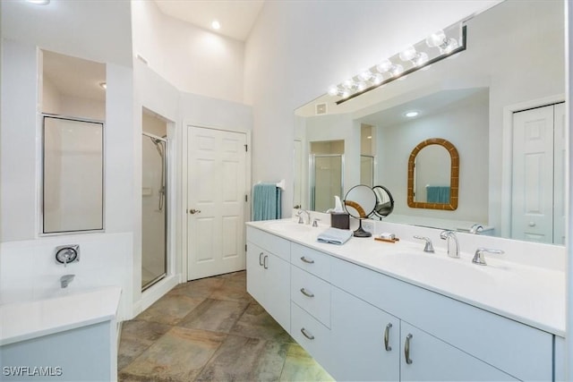 full bathroom with a stall shower, a closet, a sink, and double vanity