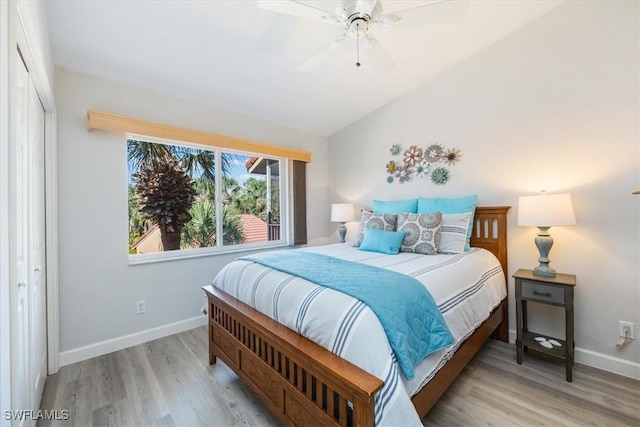 bedroom with ceiling fan, vaulted ceiling, baseboards, and wood finished floors