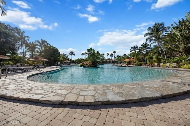 community pool featuring a water slide and a patio