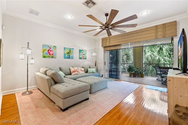 living room featuring light wood-type flooring, a ceiling fan, visible vents, and ornamental molding