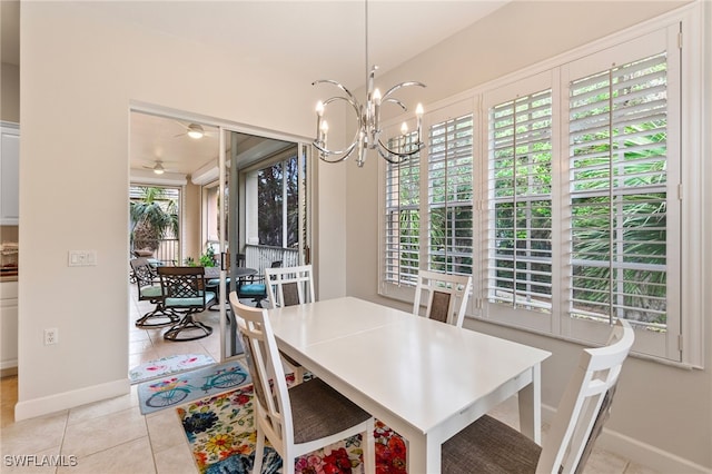 dining room with light tile patterned flooring, ceiling fan with notable chandelier, and baseboards