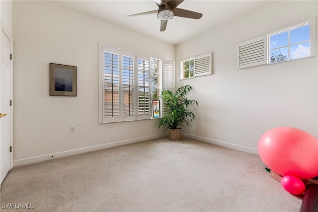 exercise room featuring baseboards, carpet floors, and a ceiling fan