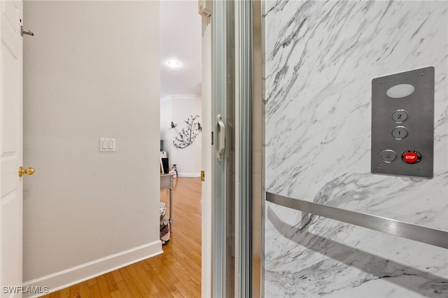 hallway featuring wood finished floors and baseboards