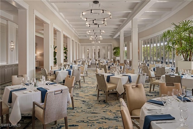 dining room featuring an inviting chandelier, beamed ceiling, light colored carpet, and ornate columns