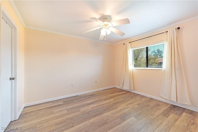 empty room with baseboards, ornamental molding, and light wood-style floors