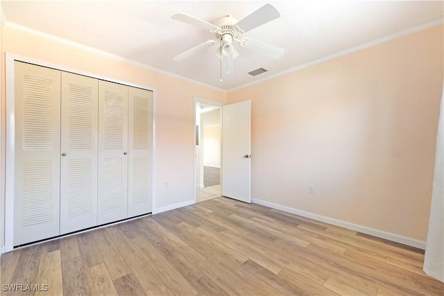 unfurnished bedroom featuring visible vents, baseboards, ornamental molding, a closet, and light wood-type flooring