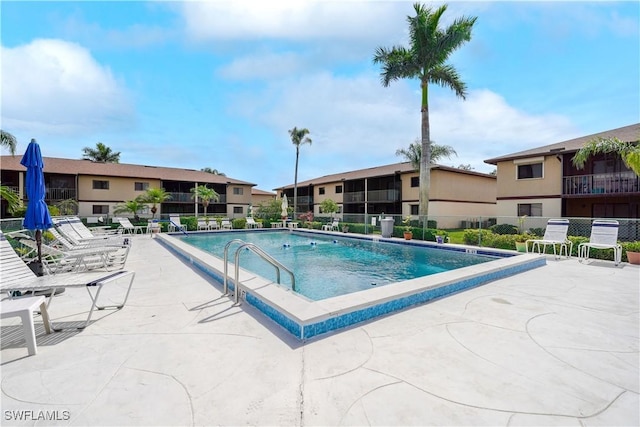 pool featuring fence and a patio