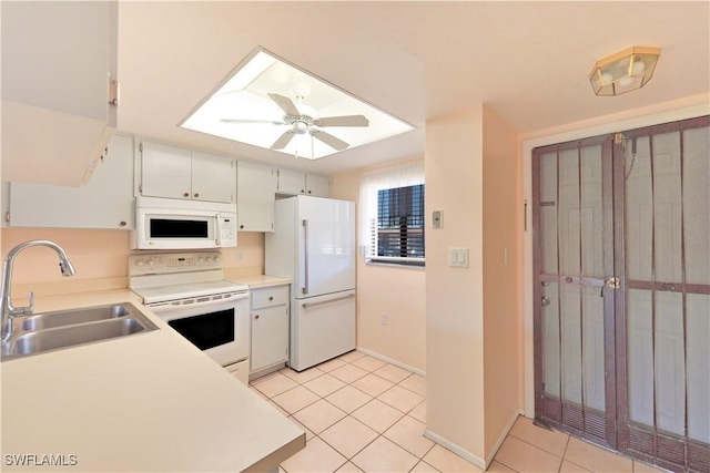 kitchen featuring white appliances, light tile patterned floors, light countertops, white cabinetry, and a sink