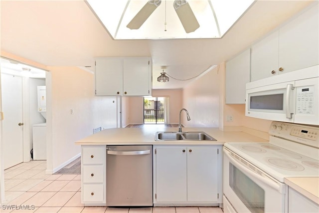 kitchen with white appliances, light countertops, a sink, and stacked washing maching and dryer