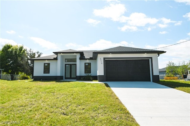 prairie-style home with a garage, a front lawn, concrete driveway, and stucco siding