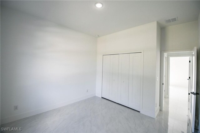 unfurnished bedroom with a closet, visible vents, and baseboards