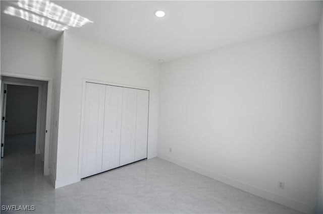 unfurnished bedroom with a closet, recessed lighting, visible vents, and baseboards