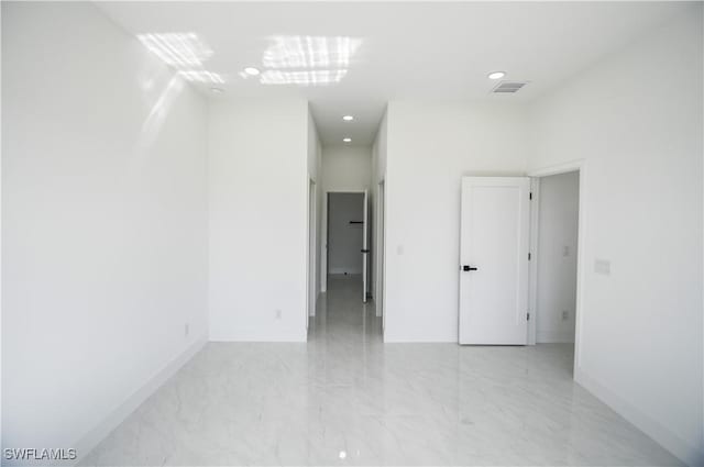 unfurnished room with marble finish floor, baseboards, and visible vents