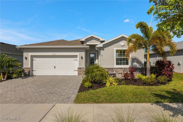 ranch-style house with stone siding, an attached garage, decorative driveway, a front lawn, and stucco siding