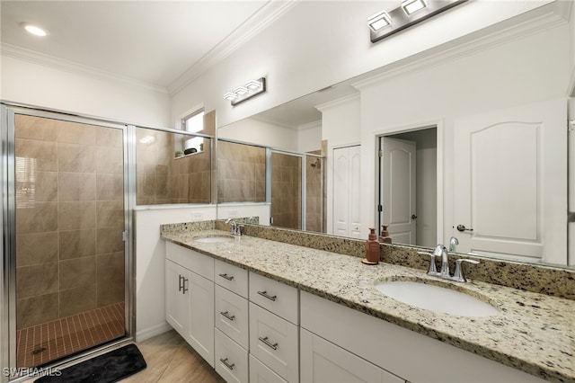 full bath with double vanity, ornamental molding, a sink, and a shower stall