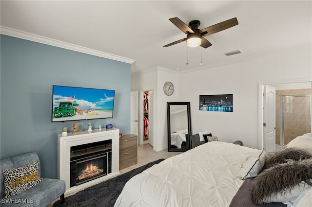 bedroom with a warm lit fireplace, carpet flooring, visible vents, a ceiling fan, and ornamental molding