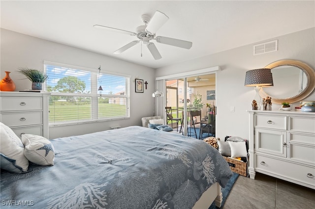 bedroom with access to outside, dark tile patterned flooring, visible vents, and a ceiling fan