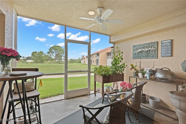 sunroom featuring ceiling fan