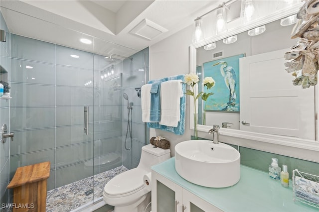 bathroom with visible vents, vanity, a shower stall, and toilet