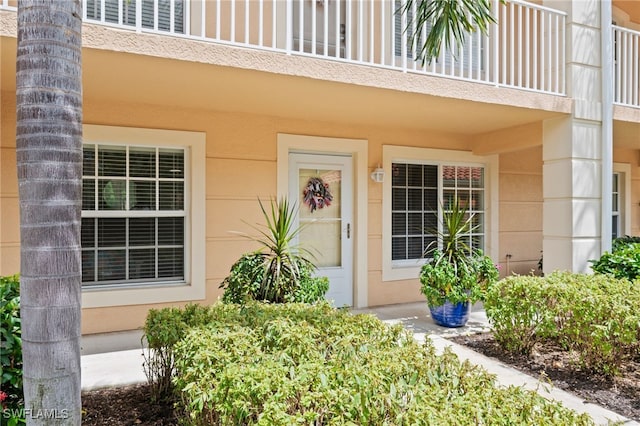 doorway to property featuring a balcony and stucco siding