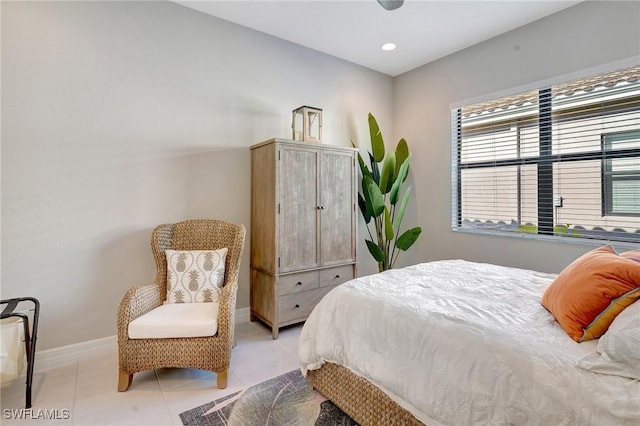 bedroom with light tile patterned floors and baseboards