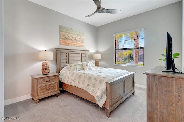 bedroom featuring light carpet, a ceiling fan, and baseboards