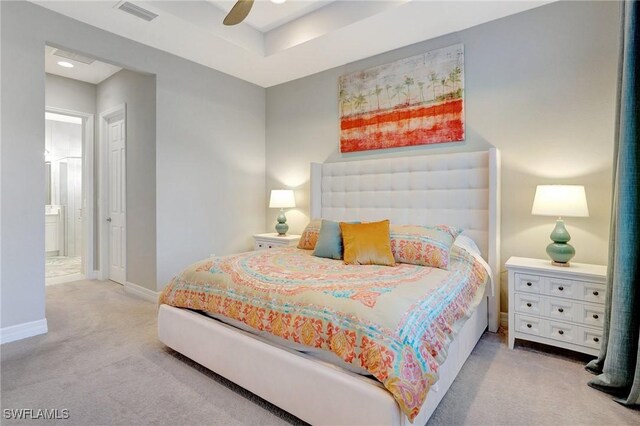 carpeted bedroom featuring a ceiling fan, visible vents, ensuite bath, and baseboards