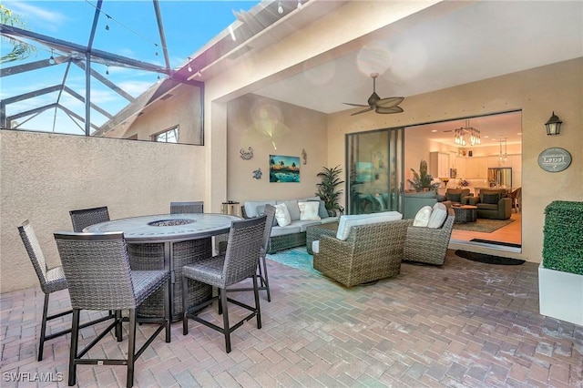 view of patio / terrace featuring ceiling fan, glass enclosure, and outdoor lounge area