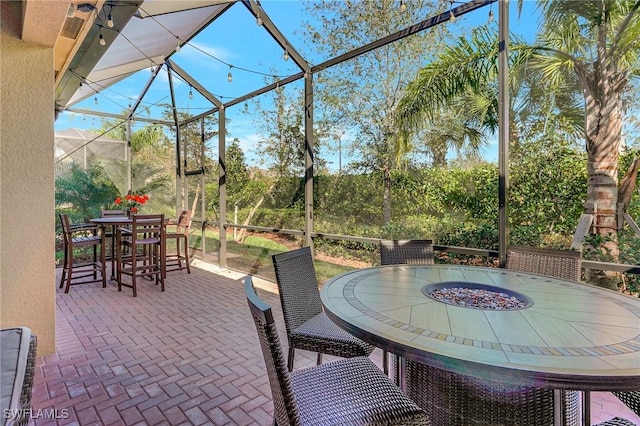 view of patio featuring outdoor dining area and a lanai