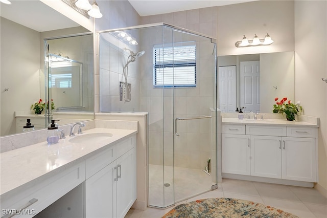 bathroom with a sink, two vanities, a shower stall, and tile patterned floors