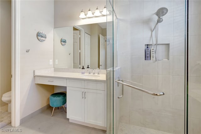 full bathroom with a stall shower, baseboards, toilet, tile patterned floors, and vanity