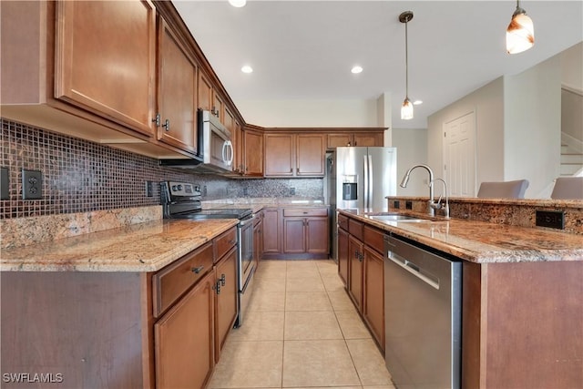 kitchen featuring hanging light fixtures, backsplash, appliances with stainless steel finishes, light tile patterned flooring, and a sink