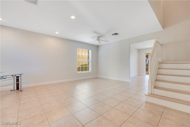 unfurnished room with light tile patterned floors, visible vents, a ceiling fan, baseboards, and stairs