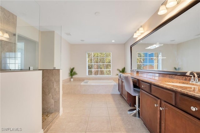 bathroom with a walk in shower, vanity, a bath, and tile patterned floors