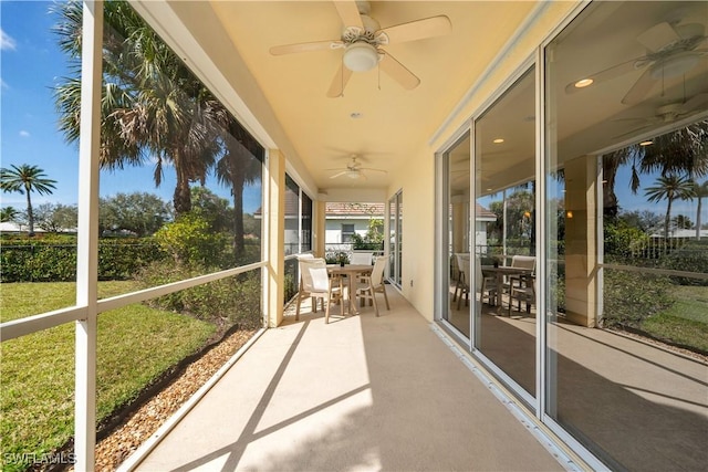 unfurnished sunroom with a ceiling fan and a healthy amount of sunlight