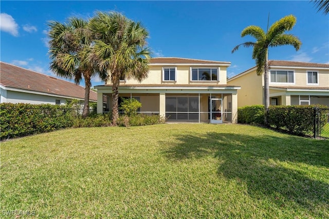 back of property featuring a lawn, fence, and a sunroom