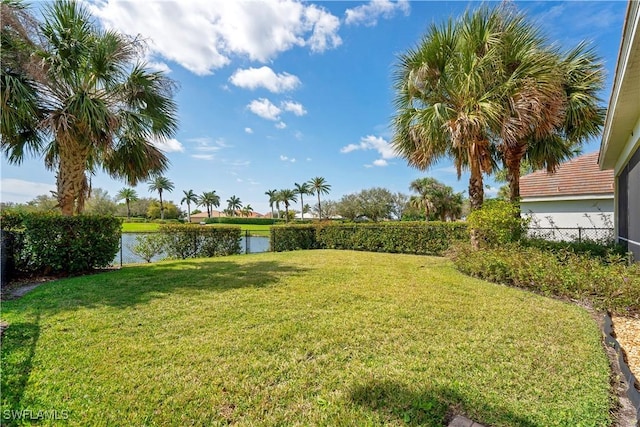 view of yard featuring a water view and fence