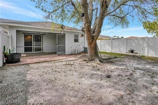 back of property with a fenced backyard, a patio, and stucco siding